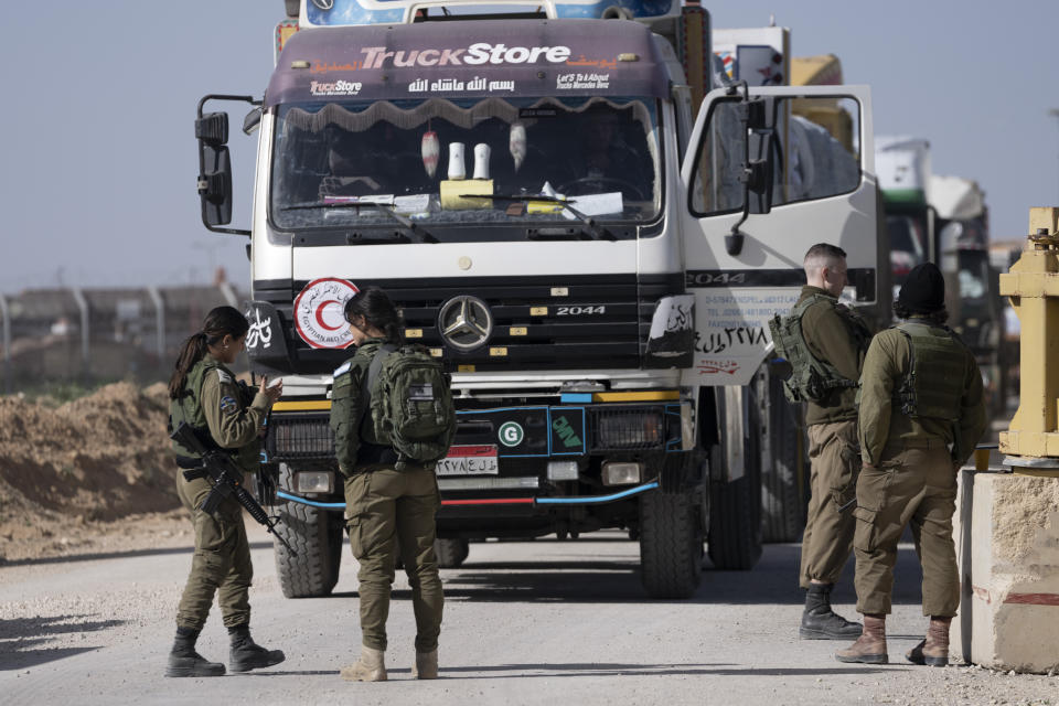 Israeli soldiers check an Egyptian truck carrying humanitarian aid for the Gaza Strip, at the Kerem Shalom Crossing in southern Israel Friday, Dec. 22, 2023. (AP Photo/Maya Alleruzzo)