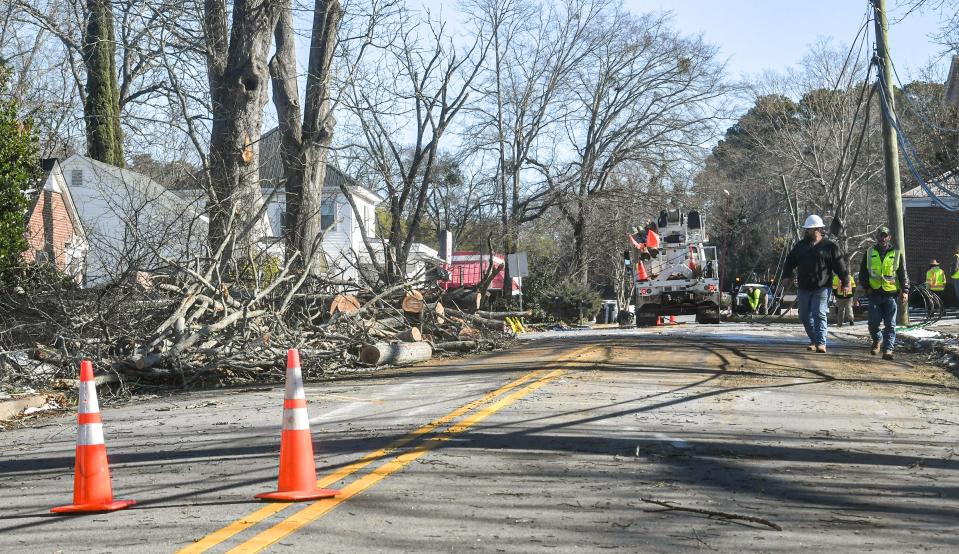 Workers chopped up a fallen oak tree and repair fallen power lines on Glenwood Avenue in Anderson Tuesday, January 18, 2022. 