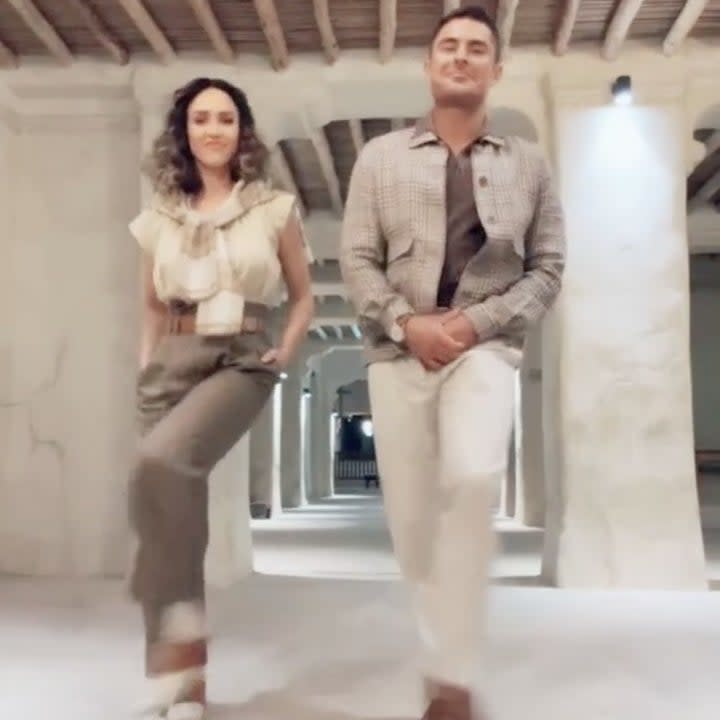 Zac and Jessica wear similar safari inspired outfits while standing under a wooden beamed ceiling