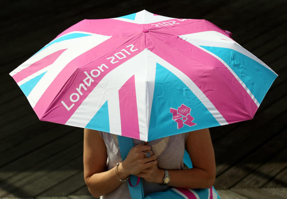 A woman holds a London 2012 branded umbrella at the launch of the London Olympic Games official merchandise on July 30, 2010 in London, England. (Photo by Oli Scarff/Getty Images)