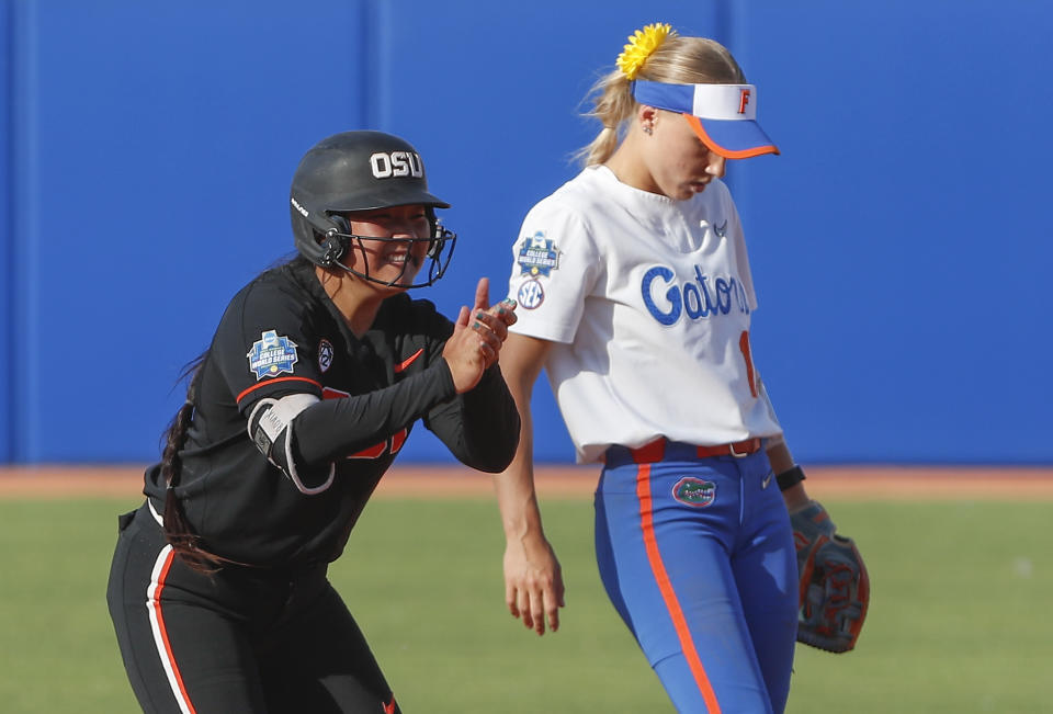 Oregon State's Xiao Gin (8) celebrates after reaching second base in the first inning of an NCAA softball Women's College World Series game against Florida on Thursday, June 2, 2022, in Oklahoma City. (AP Photo/Alonzo Adams)