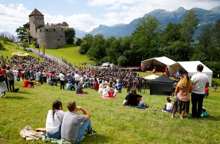 People listen the speech of Hereditary Prince Alois of Liechtenstein in front of Schloss Vaduz castle in Vaduz
