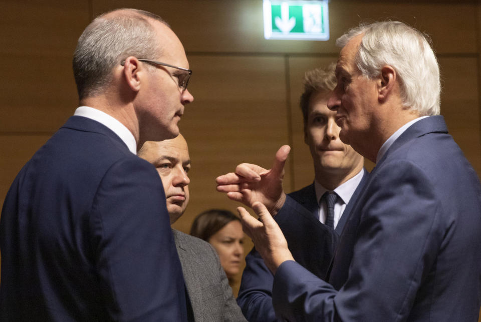 FILE - In this Oct. 15, 2019 file photo, EU chief Brexit negotiator Michel Barnier, right, speaks with Irish Foreign Minister Simon Coveney, left, during a meeting in Luxembourg. Irish Foreign Minister Simon Coveney has accused Britain of "shifting the playing field" and dismissing EU proposals without seeing them. "This is being seen across the European Union as the same pattern over and over again, the EU tries to solve problems, the U.K. dismisses the solutions before they are even published and asks for more," Coveney said. (AP Photo/Virginia Mayo, File)
