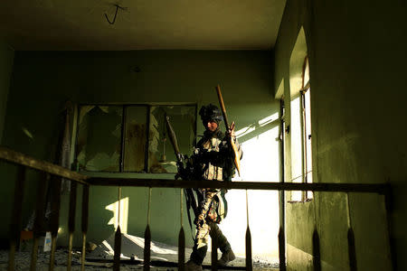 A member of Iraqi rapid response forces carries his weapons during a battle with Islamic State militants in the Mithaq district of eastern Mosul. REUTERS/Thaier Al-Sudani