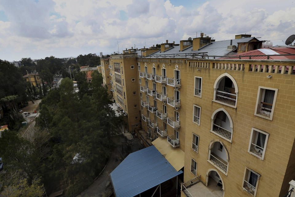 In this Friday, April 19, 2019 photo, the Ledra Palace Hotel is seen from the roof inside the U.N. buffer zone in the divided capital Nicosia, Cyprus. This grand hotel still manages to hold onto a flicker of its old majesty despite the mortal shell craters and bullet holes scarring its sandstone facade. Amid war in the summer of 1974 that cleaved Cyprus along ethnic lines, United Nations peacekeepers took over the Ledra Palace Hotel and instantly turned it into an emblem of the east Mediterranean island nation's division. (AP Photo/Petros Karadjias)