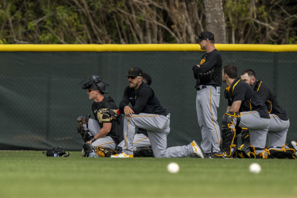 Pittsburgh Pirates players react as a guest gets medical attention during spring training baseball camp in Bradenton, Fla., Tuesday, Feb. 21, 2023. “He was attended to by Pirates medical personnel, is alert and responsive, and being transported to a local hospital for further evaluation,” the Pirates said in a statement. (Ben B. Braun/Pittsburgh Post-Gazette via AP)