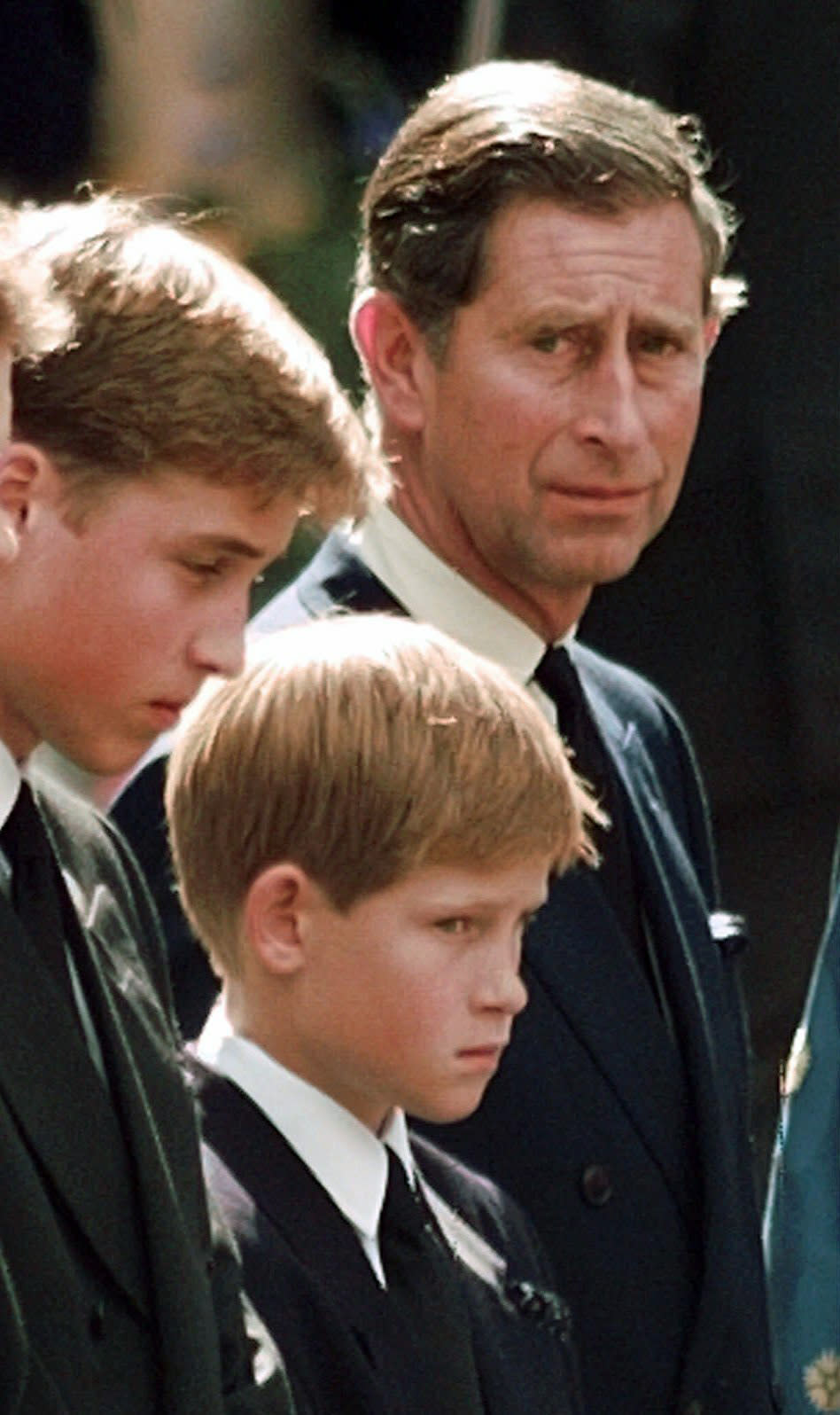 FILE - In this Saturday, Sept. 6, 1997 file photo, Britain's Prince Charles, the Prince of Wales and his sons Prince William, left and Prince Harry wait for the coffin of Princess Diana to be loaded into a hearse outside of Westminster Abbey, in London. Princess Diana’s little boy, the devil-may-care red-haired prince with the charming smile is about to become a father. The arrival of the first child for Prince Harry and his wife Meghan will complete the transformation of Harry from troubled teen to family man, from source of concern to source of national pride. (John Gaps III, Pool Photo via AP, File)