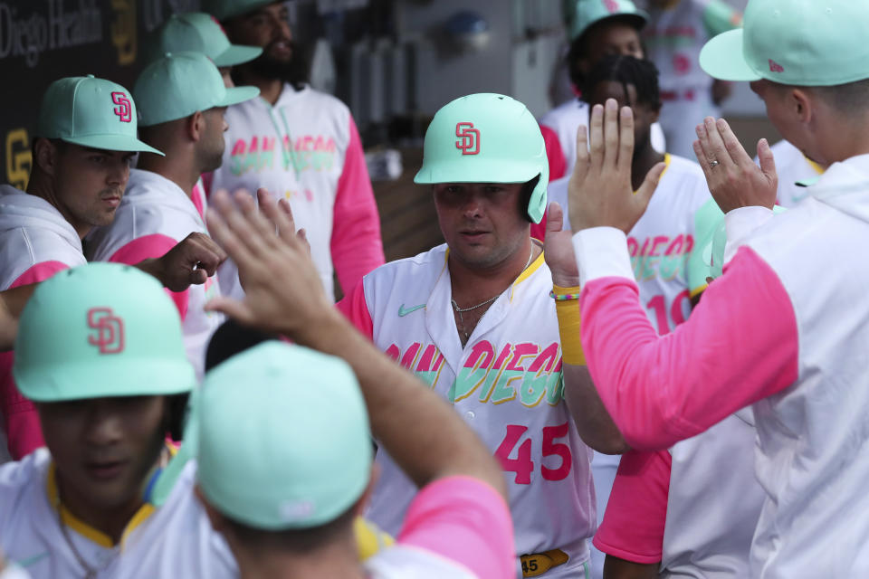 San Diego Padres' Luke Voit (45) is congratulated by teammates after scoring on a double by Austin Nola against the Arizona Diamondbacks during the second inning of a baseball game Friday, July 15, 2022, in San Diego. (AP Photo/Derrick Tuskan)