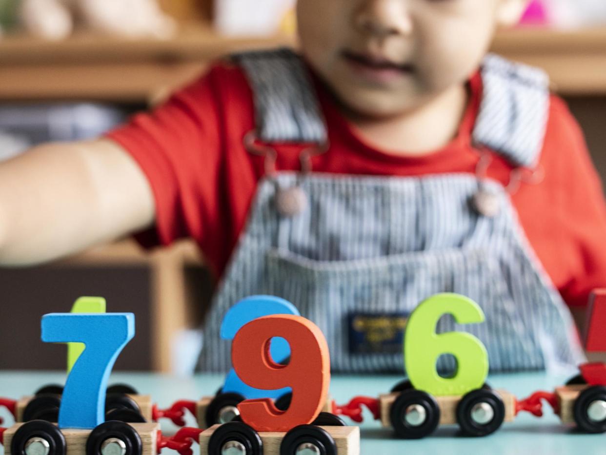 Little boy playing mathematics wooden toy at nursery: Getty Images/iStockphoto