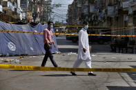 Pakistani investigators examine at the site of Friday's bomb explosion in Rawalpindi, Pakistan, Saturday, June 13, 2020. A powerful bomb exploded at a crowded bazaar in the Pakistani garrison city of Rawalpindi on Friday, killed and wounded some persons, police and government officials said. (AP Photo/Anjum Naveed)