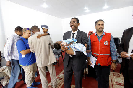 Members of Libyan Red Crescent hand over the children of Sudanese Islamic State members who operated in Libya, to a Sudanese official, in Misrata, Libya August 20, 2017. REUTERS/Ismail Zitouny