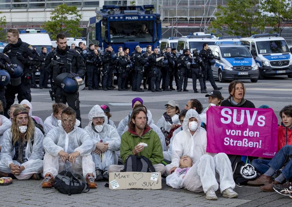 Activists block the main entrance of the fairground in Frankfurt, Germany, Sunday, Sept. 15, 2019. They protest against the government's transport policy on occasion of the IIA Auto Show taking place. The poster reads: 'SUV's out of the streets'. (AP Photo/Michael Probst)