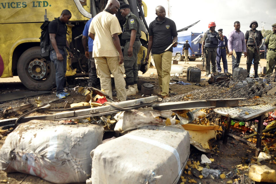 Police officers inspect a passenger bus following an explosion at a bus station in Kano, Nigeria. Thursday July 24, 2014. According to police, one person was killed and eight others injured after a bomb exploded out of a discarded refrigerator at the bus station. Kano State Police Commissioner Aderenle Shinaba said "the investigation into the terrorism is ongoing." (AP Photo/Muhammed Giginyu)