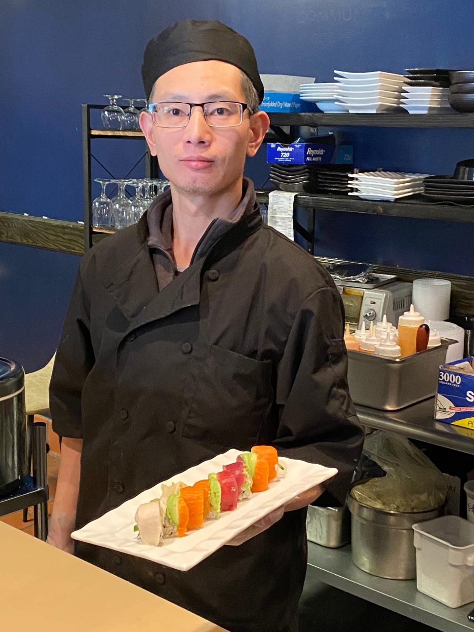 Chef Hua Pan serves a rainbow maki sushi roll at Malis Sushi & Ramen restaurant in Raynham on Thursday, Feb. 8, 2024.