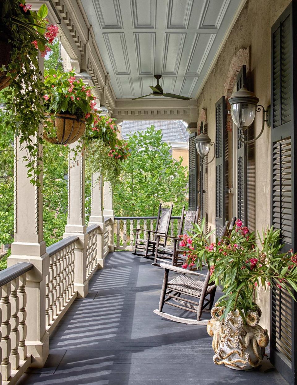 a walkway with plants and chairs