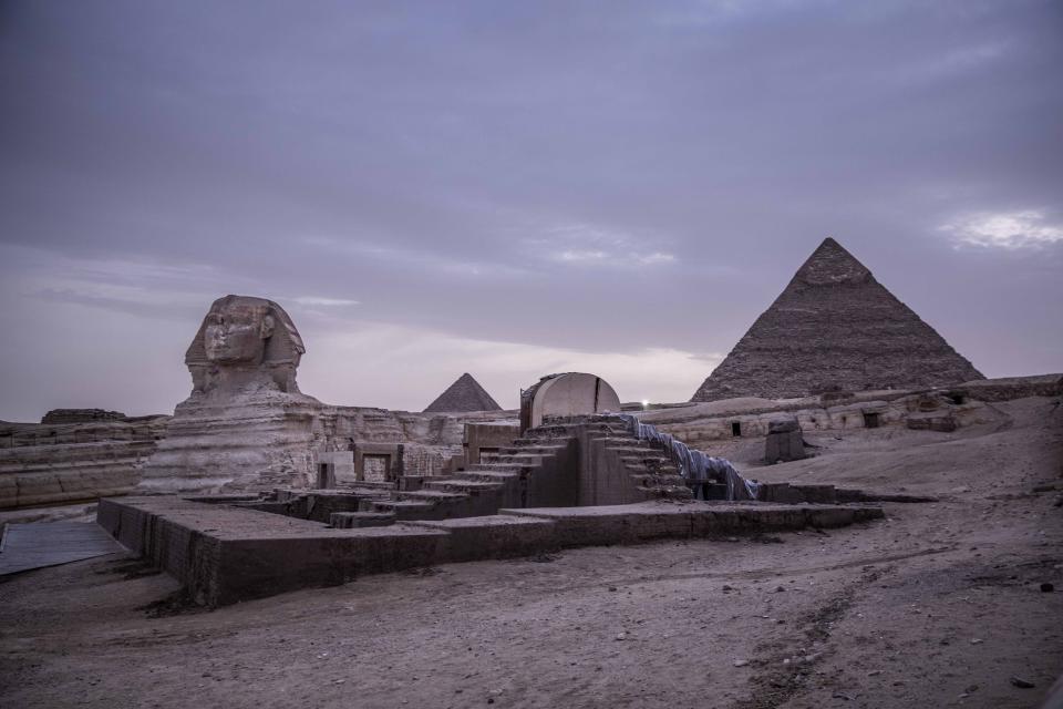 FILE - This March 30, 2020 file photo, shows the empty Giza Pyramids and Sphinx complex on lockdown due to the coronavirus outbreak in Egypt. In July, fearing further economic fallout, the government reopened much of society and welcomed hundreds of international tourists back to resorts, even as daily reported deaths exceeded 80. Restaurants and cafes are reopening with some continued restrictions, and masks have been mandated in public. (AP Photo/Nariman El-Mofty, File)