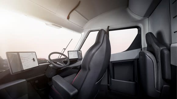 The interior of Tesla Semi, featuring a center-positioned driver's seat and two touchscreen displays.