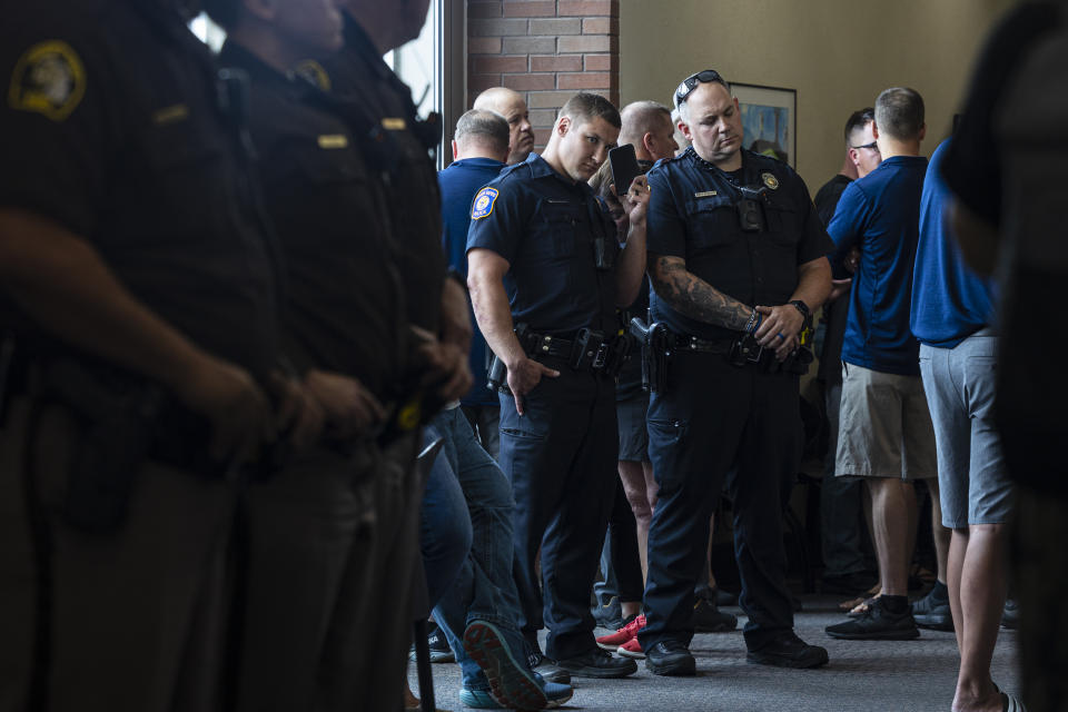 Supporters of Christopher Schurr gather in the hallway and listen on a live stream outside of Kent County District Court as Grand Rapids Police officer Schurr appeared on video from jail, Friday, June 10, 2022 in Grand Rapids, Mich. A judge facing a packed courtroom set bond Friday at $100,000 for Schurr, a Michigan police officer charged with second-degree murder in the death of Patrick Lyoya, a Black man who was shot in the back of the head in April. (Joel Bissell/The Grand Rapids Press via AP)