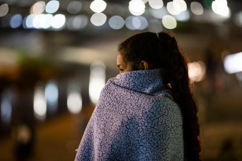 Venezuelan migrants set up an encampment on the south bank of the Rio Grande in Juárez. Many of the migrants have been expelled under Title 42 after seeking asylum and are hoping to be accepted as refugees in the U.S. In this photo, a woman looks toward the U.S. as she tries to stay warm.