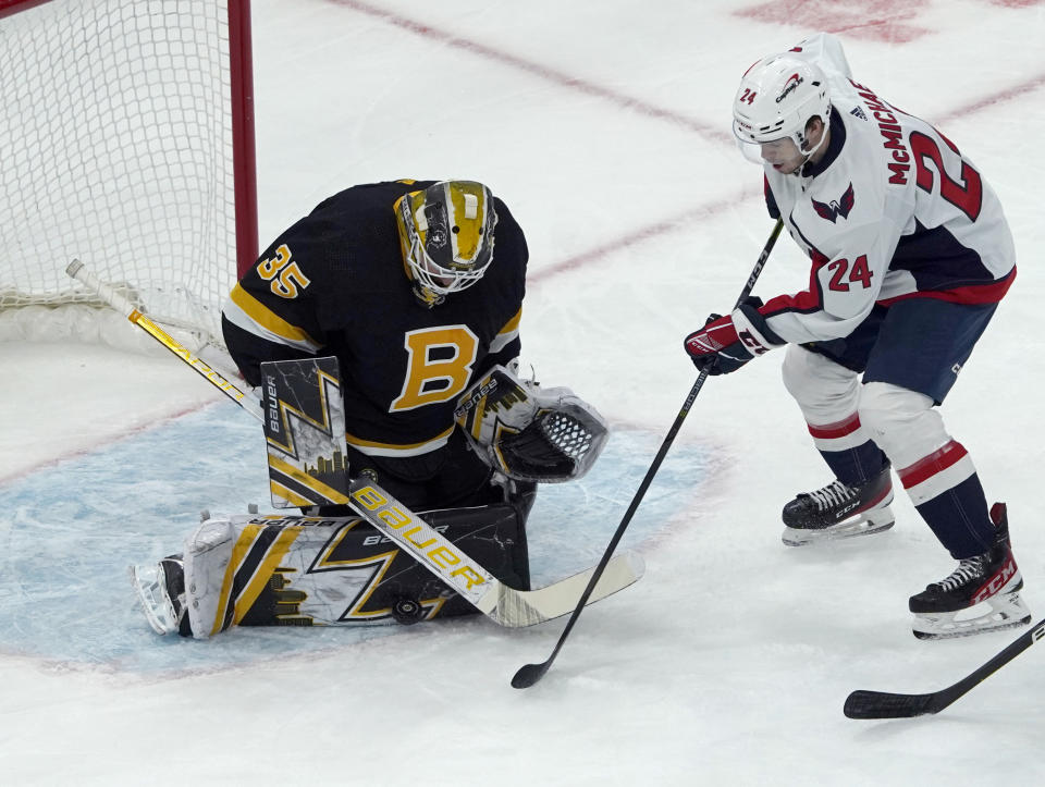 Boston Bruins goaltender Linus Ullmark (35) makes a pad-save on a shot by Washington Capitals center Connor McMichael (24) during the first period of an NHL hockey game, Thursday, Jan. 20, 2022, in Boston. (AP Photo/Mary Schwalm)