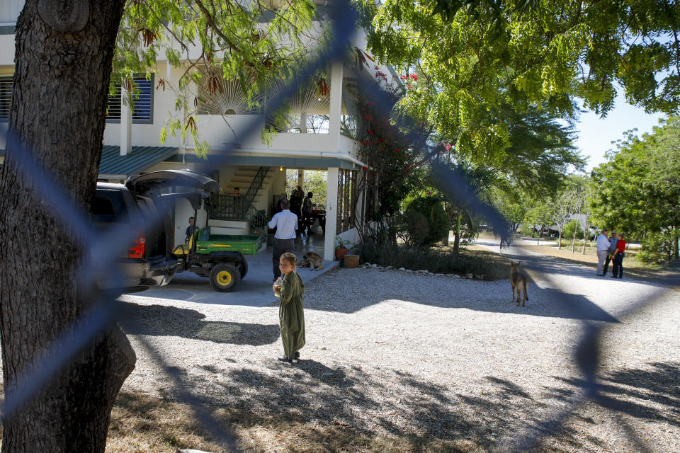 Unidentified people gather at the Christian Aid Ministries headquarters in Titanyen, north of Port-au-Prince, Haiti, Thursday, Dec. 16, 2021. Twelve remaining members of a U.S.-based missionary group who were kidnapped two months ago have been freed, according to the group and Haitian police. (AP Photo/Odelyn Joseph)