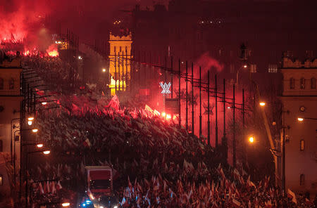 People carry Polish flags and burn flares during a march marking the 100th anniversary of Polish independence in Warsaw, Poland November 11, 2018. Agencja Gazeta/Dawid Zuchowicz via REUTERS