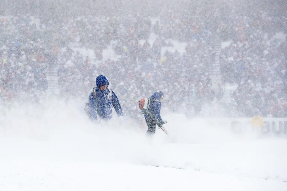 Workers blow snow off the field during the first quarter of the game between the Buffalo Bills and Indianapolis Colts on Dec. 10, 2017 at New Era Field in Orchard Park, N.Y.