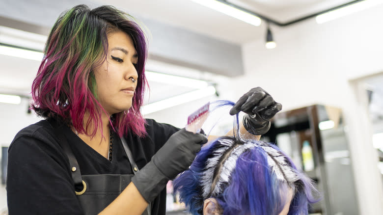 Hairdresser bleaching client's roots