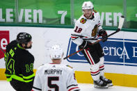 Chicago Blackhawks left wing Alex DeBrincat (12) celebrates after scoring the game-winning goal during overtime of an NHL hockey game against the Dallas Stars, Sunday, Feb. 7, 2021, in Dallas. (AP Photo/Sam Hodde)