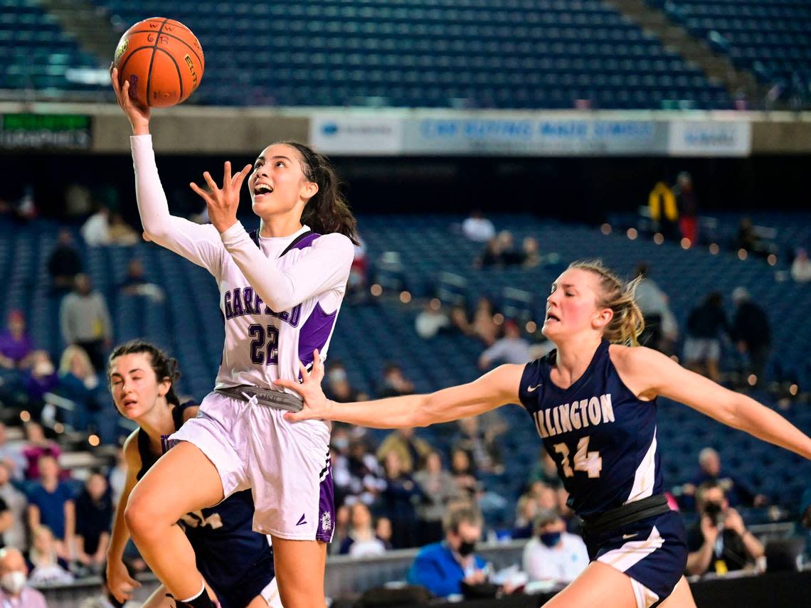 Garfield guard Katie Fiso (22) goes in for a layup as Arlington guard Keira Marsh (14) defends during the fourth quarter of a Class 3A state tournament semifinal game on Friday, March 4, 2022, at the Tacoma Dome, in Tacoma, Wash.