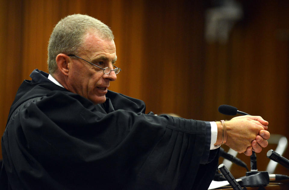 South African chief state prosecutor Gerrie Nel gestures as he explains a possible scenario into how Oscar Pistorius might have fired on girlfriend Reeva Steenkamp, in court in Pretoria, South Africa, Monday, April 14, 2014. A judge temporarily adjourned the murder trial of Oscar Pistorius after the athlete started to sob while testifying about the moments before he killed girlfriend Reeva Steenkamp in his home last year. (AP Photo/Antoine de Ras, Pool)