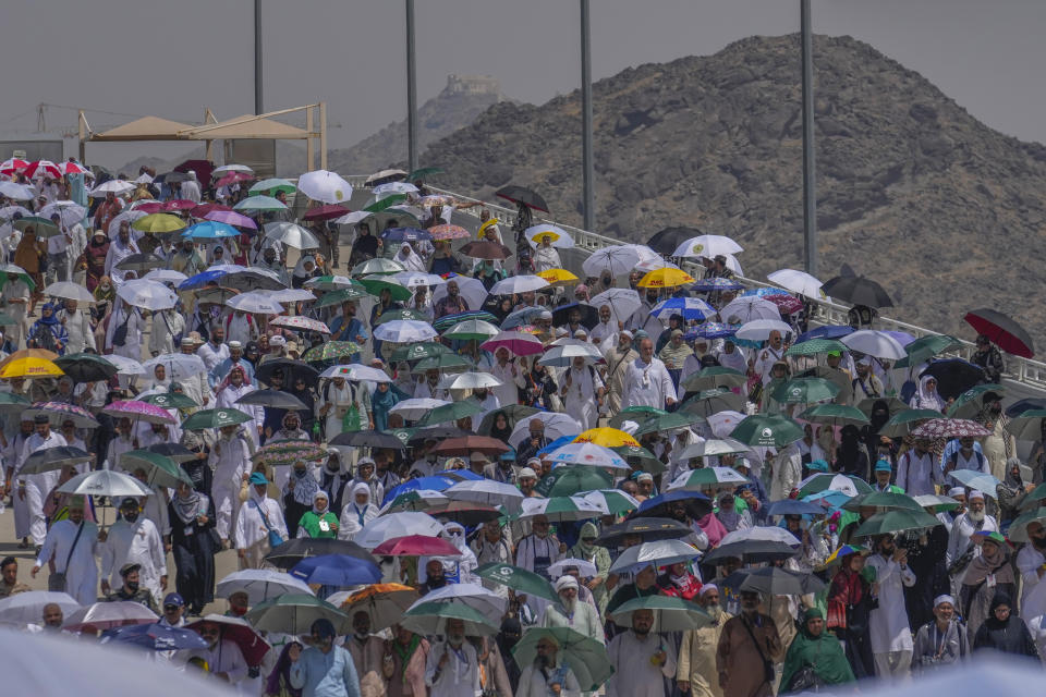 Muslim pilgrims use umbrellas to shield themselves from the sun as they arrive to cast stones at pillars in the symbolic stoning of the devil, the last rite of the annual hajj, in Mina, near the holy city of Mecca, Saudi Arabia, Tuesday, June 18, 2024. Muslim pilgrims were wrapping up the Hajj pilgrimage in the deadly summer heat on Tuesday with the third day of the symbolic stoning of the devil, and the farewell circling around Kaaba in Mecca's Grand Mosque. (AP Photo/Rafiq Maqbool)