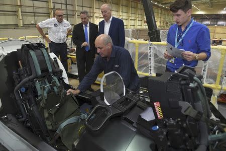 Managing Director Tony Birmingham (3rd R) shows International Trade Secretary Liam Fox (2nd L) a Euro Fighter simulator, during a visit to EDM Ltd in Newton Heath, Manchester, Britain September 29, 2016. REUTERS/Anthony Devlin