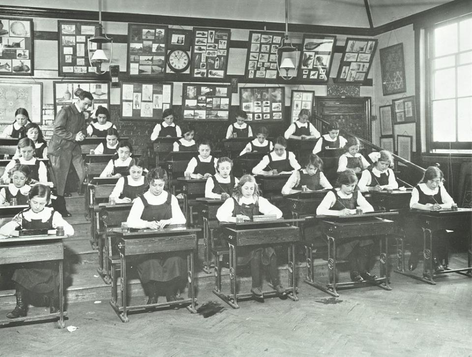 Girls in rows of desks work diligently