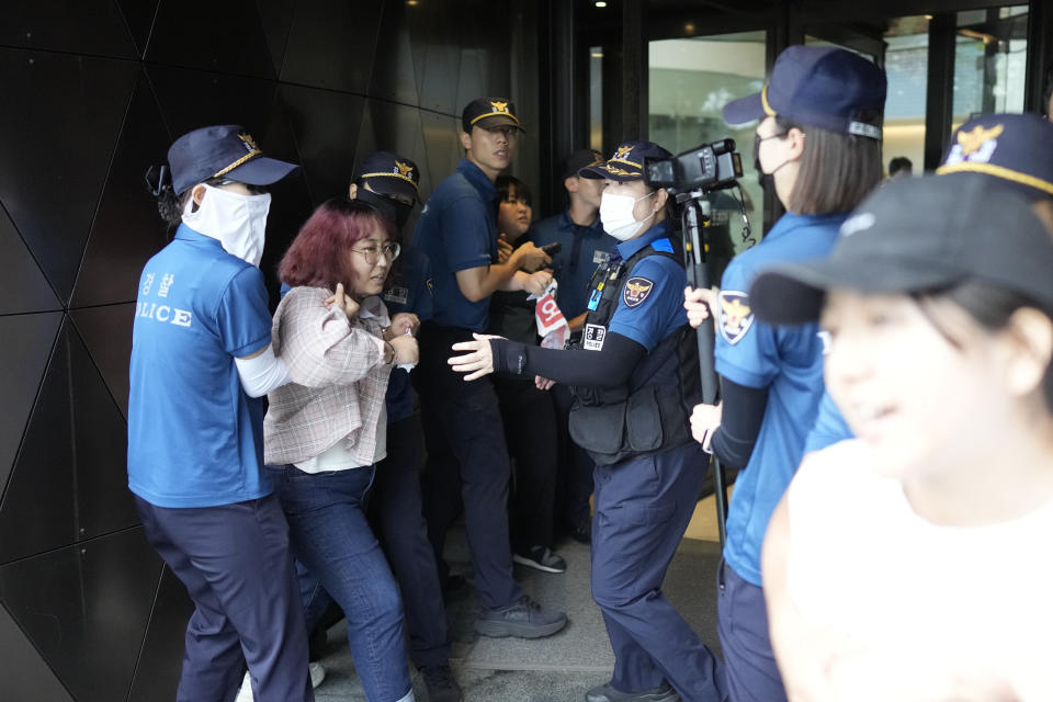 South Korean students are detained by police officers as they attempt to enter to Japanese Embassy to protest denouncing to release treated radioactive water into the sea from the damaged Fukushima nuclear power plant, at a building which houses Japanese Embassy, in Seoul, South Korea, Thursday, Aug. 24, 2023. The operator of the tsunami-wrecked Fukushima Daiichi nuclear power plant says it has begun releasing its first batch of treated radioactive water into the Pacific Ocean — a controversial step, but a milestone for Japan's battle with the growing radioactive water stockpile. (AP Photo/Lee Jin-man)