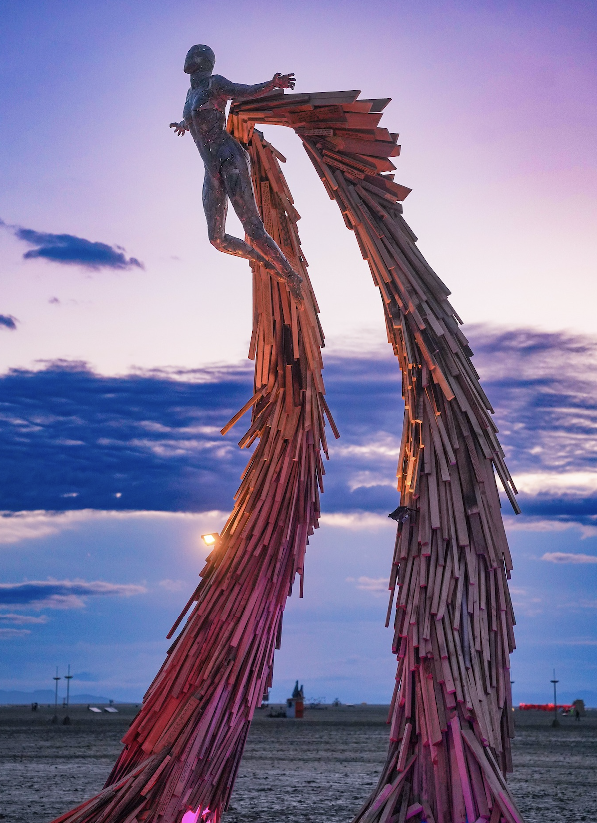 An art installation featuring a spirit soaring against the backdrop of the Black Rock Desert at twilight.