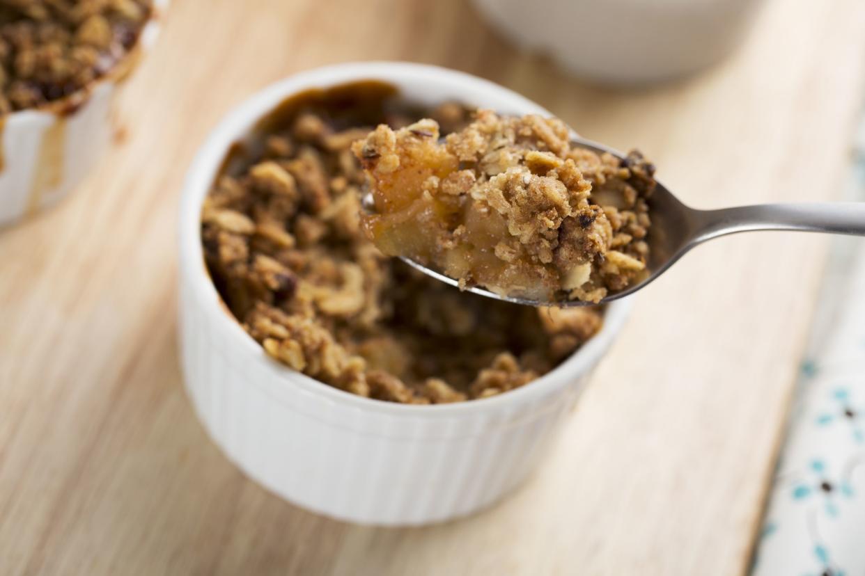 Spoon full of fresh apple crumble from single serving