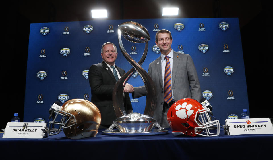 Notre Dame head coach Brian Kelly, left, and Clemson head coach Dabo Swinney shake hands and pose for photos after the NCAA Cotton Bowl football coaches' news conference in Dallas, Friday, Dec. 28, 2018. Notre Dame is scheduled to play Clemson in the NCAA Cotton Bowl semi-final playoff Saturday. (AP Photo/LM Otero)