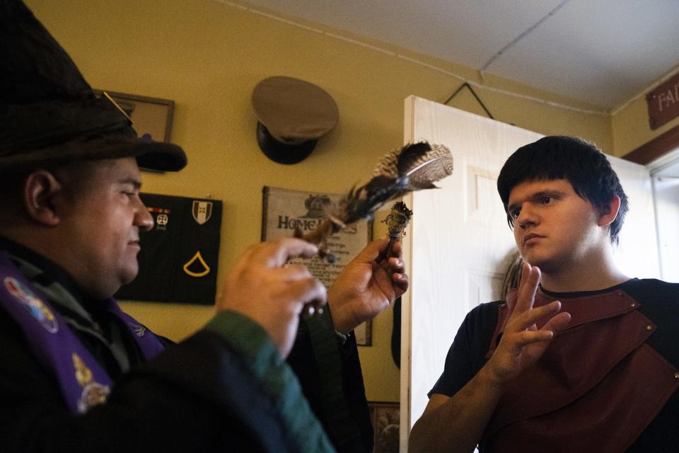 Jesse Serpa, a witch that practices paganism, (left) cleanse the energy of his son, who preferred to remain nameless, at his home as he conducts a ritual to honor recent loved ones he's lost at his home on Oct. 28, 2022, in Peoria.