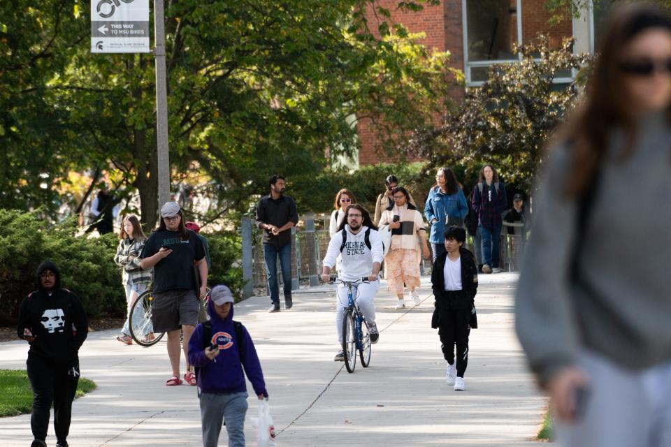 People commute on the campus of Michigan State University, Monday, Oct. 9, 2023.