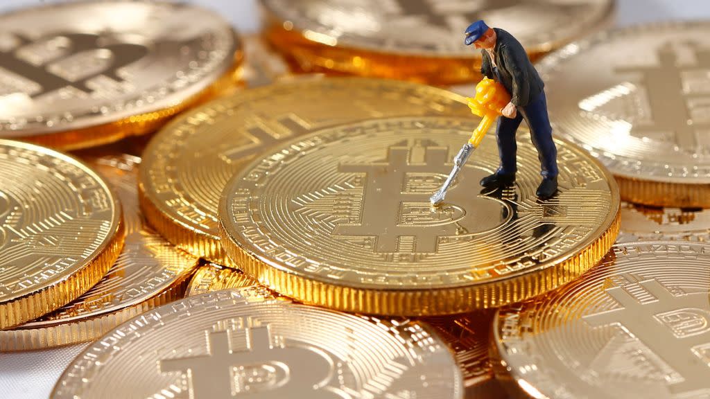 A small toy figure is seen on representations of the Bitcoin virtual currency in this illustration picture, December 26, 2017.