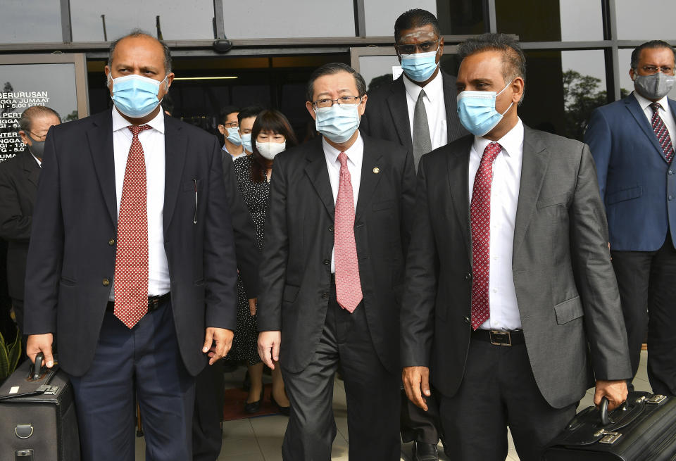 Malaysian former Finance Minister and Penang Chief Minister Lim Guan Eng, center, leaves courthouse in Butterworth, Malaysia, Monday, Aug. 10, 2020. Lim pleaded not guilty to a second graft charge relating to a $1.5 billion undersea tunnel project. Lim has slammed the charges as political persecution by the new government. (AP Photo/Gary Chuah)