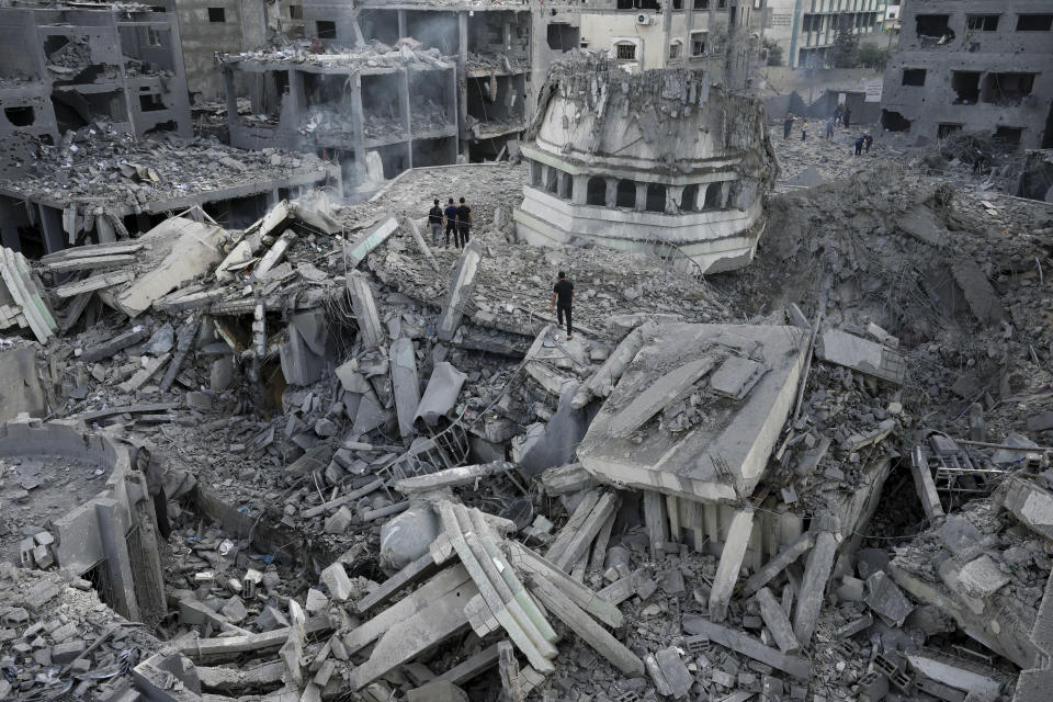 Palestinos revisan los restos de la mezquita Yassin, destruida tras un ataque aéreo israelí sobre el campo de refugiados de Shati, en la Ciudad de Gaza, el 9 de octubre de 2023. (AP Foto/Adel Hana)