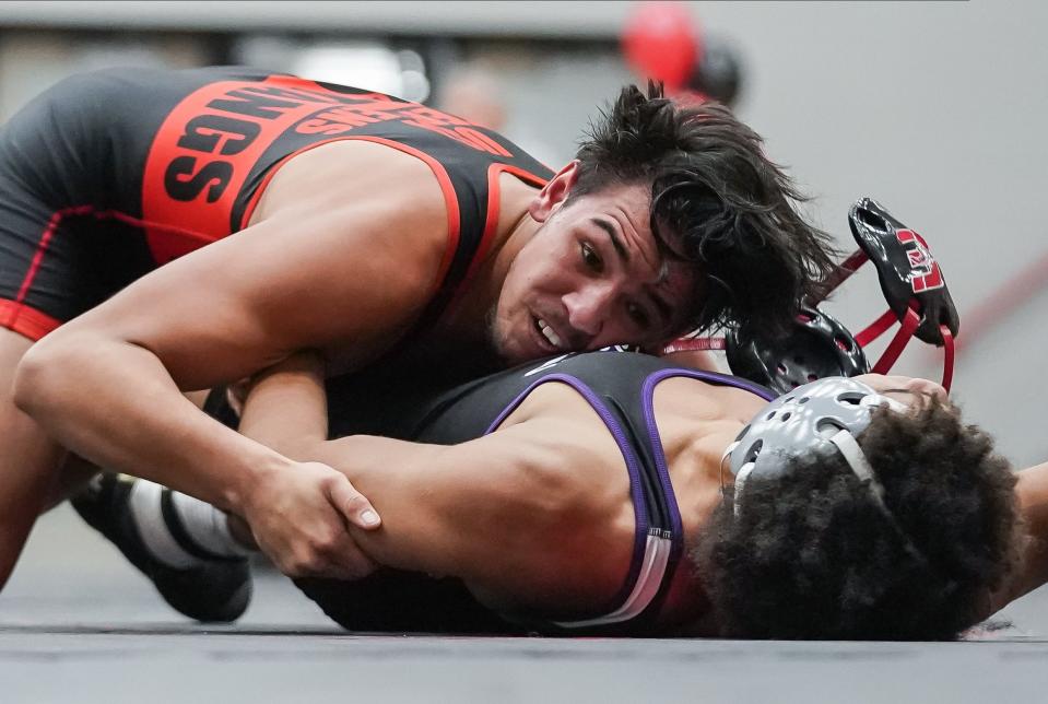 Edgewood’s Cayleb Stephens (top) loses his mask as he wrestles against Bloomington South’s Quincy Edwards in the 157-pound match during their dual meet at Edgewood on Thursday, Jan. 18, 2024.