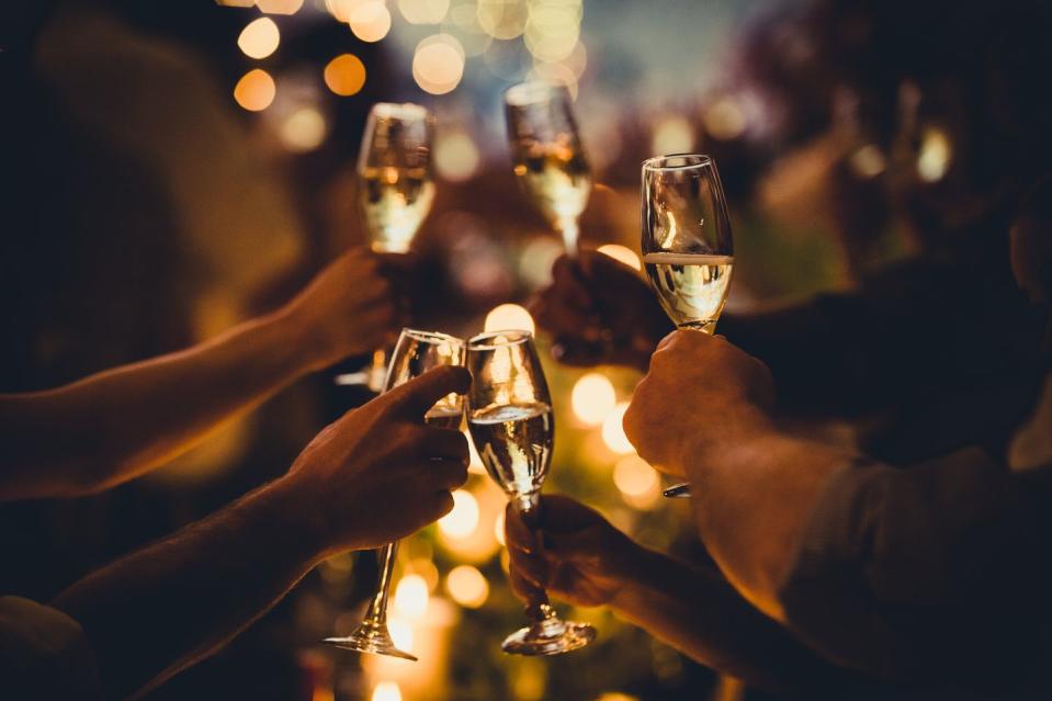 numerous hands holding champagne flutes with champagne celebratory toast silhouettes