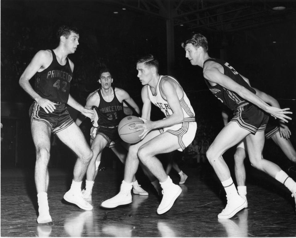 Rutgers' Bob Lloyd (center, in white) drives against Princ.eton and Bill Bradley (No. 42)