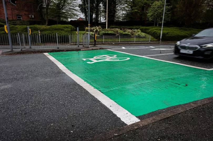 The new cycle zone painted at traffic lights on Church Lane - ten yards from a wrecked road surface which has not been repaired