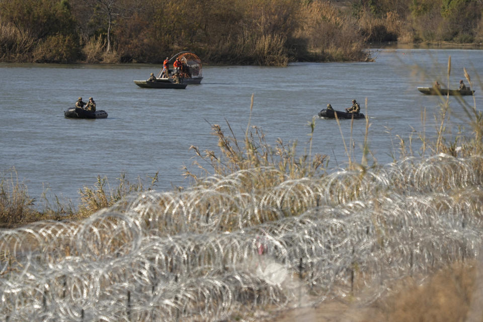 Guardsmen move along the Rio Grande in small boats past rows of concertina wire placed to help curb illegal crossings, Thursday, Feb. 1, 2024, in Eagle Pass, Texas. (AP Photo/Eric Gay)