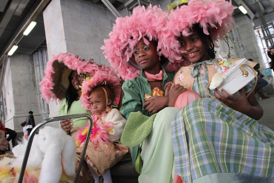 Dressed for the occasion, from left, Keosha Brown, 19, Brown's cousin Xiomara Lumsden, 4, Ariah Scott-Johnson, 10, and Felicia Bookard, 10, pose for photographs as they take part in the Easter Parade along New York's Fifth Avenue, Sunday, April 20, 2014. (AP Photo/Tina Fineberg)