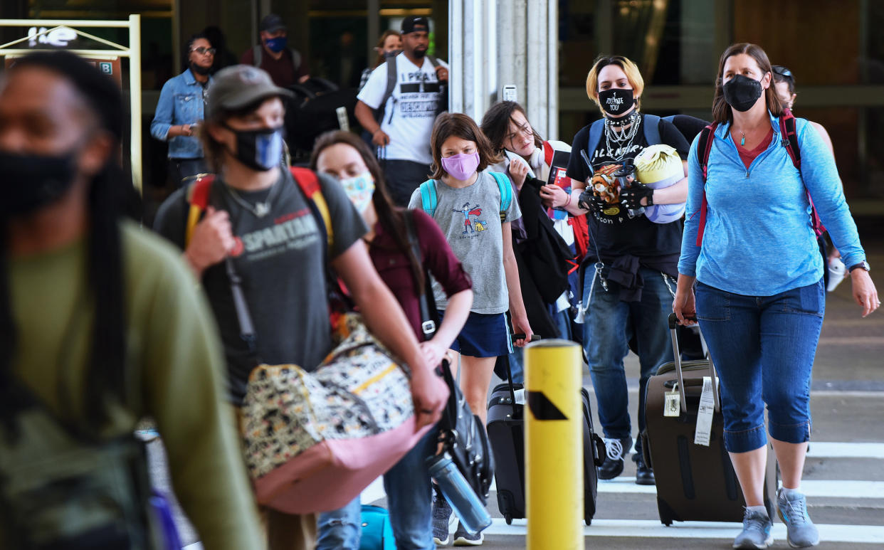 ORLANDO, FLORIDA, UNITED STATES - 2021/05/28: Travelers wearing protective face masks arrive at Orlando International Airport on the Friday before Memorial Day. 
As more and more people have received the COVID-19 vaccine, American Automobile Association (AAA) is predicting more than 37 million Americans will travel more than 50 miles this Memorial Day weekend, many for the first time since the pandemic began. (Photo by Paul Hennessy/SOPA Images/LightRocket via Getty Images)